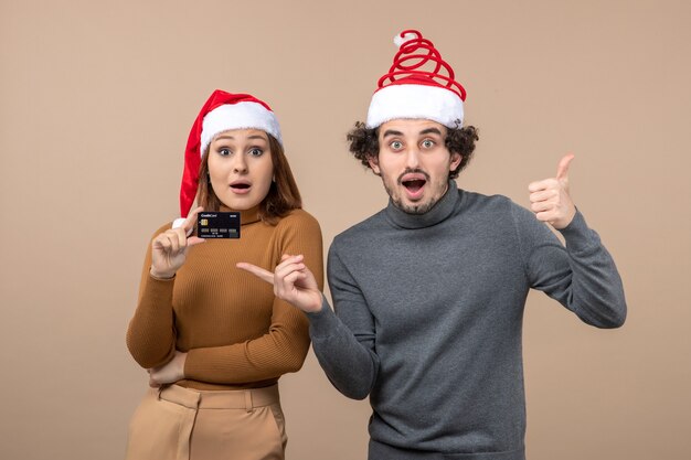 A couple is standing next to the Christmas tree