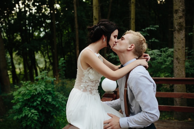 Free photo couple kissing in a bridge