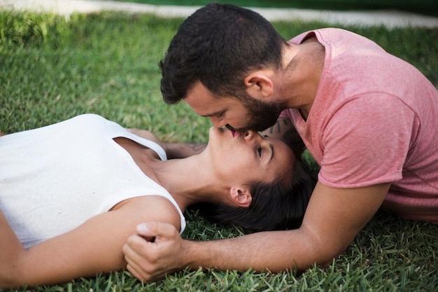 公園でお互いにキスをするカップル