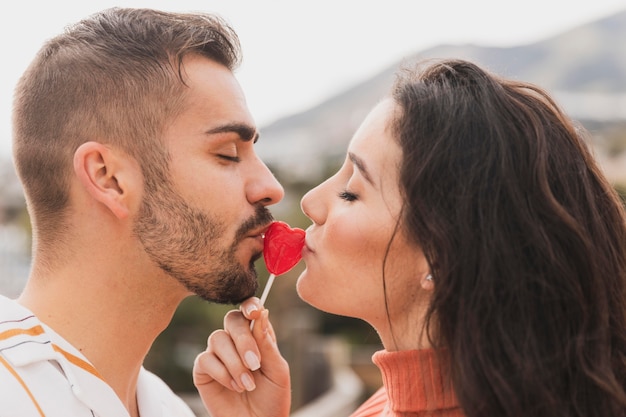 Couple kissing lollipop