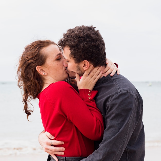海岸でキスするカップル