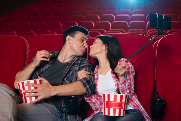 Coppia baciarsi e scattare selfie nel cinema