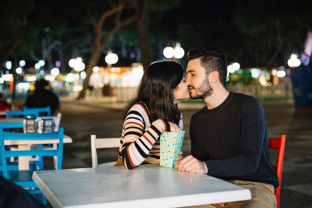 Foto gratuita coppia baciarsi in un parco a tema