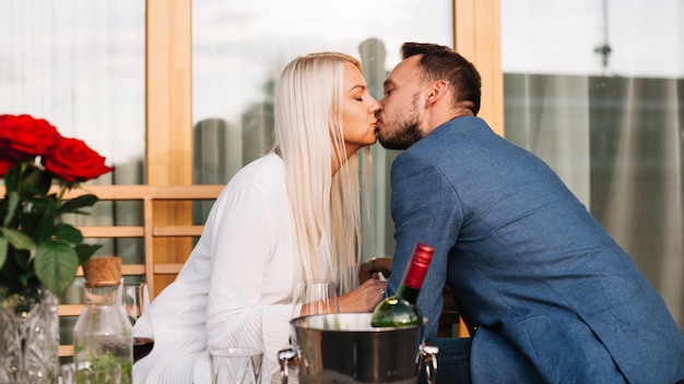 Free photo couple kissing together in the restaurant