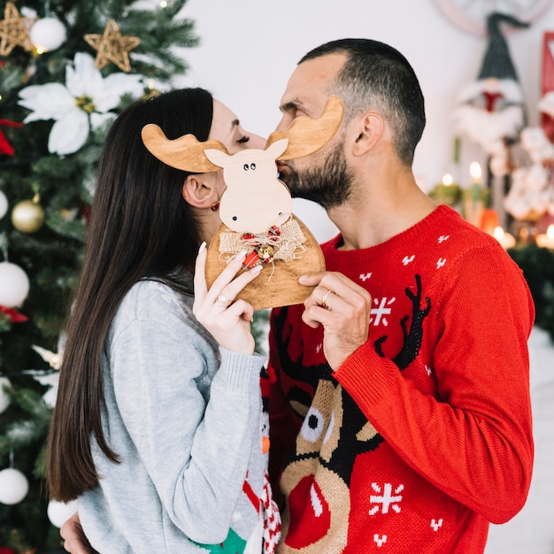 Couple kissing behind toy deer