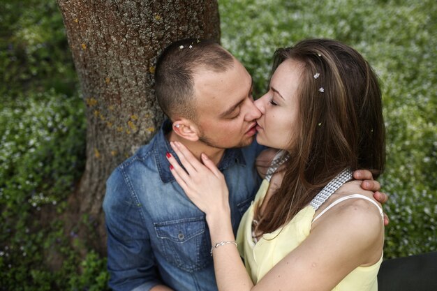 "Couple kissing at tree"