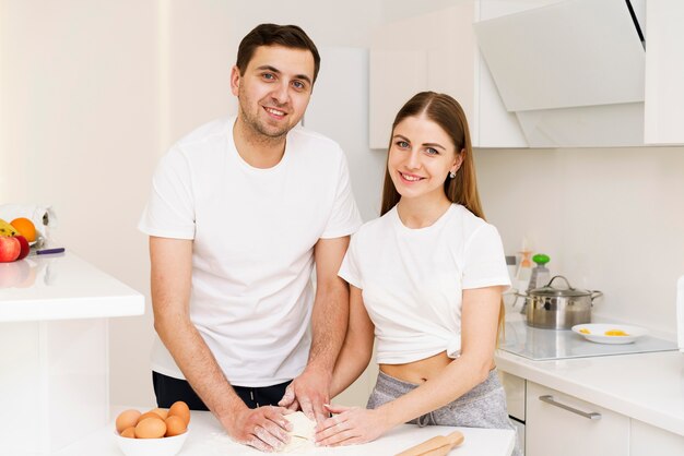 Couple in kitchen preparing dough