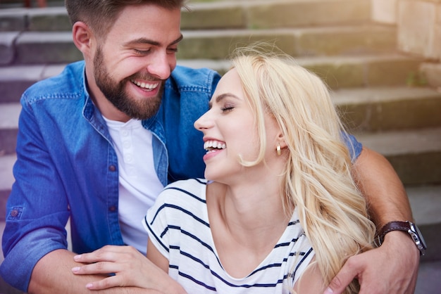 Couple laughing loudly on the steps