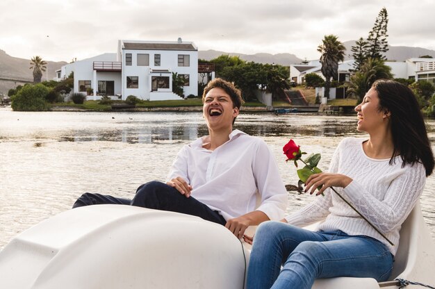 Couple laughing while sailing on a pedal boat