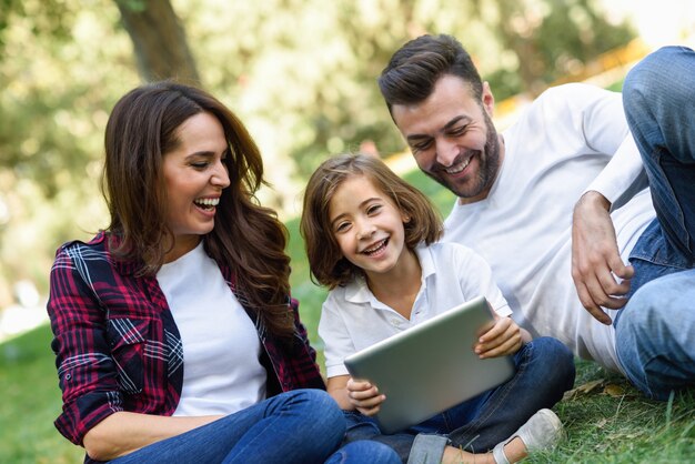 Couple laughing with their daughter and a laptop