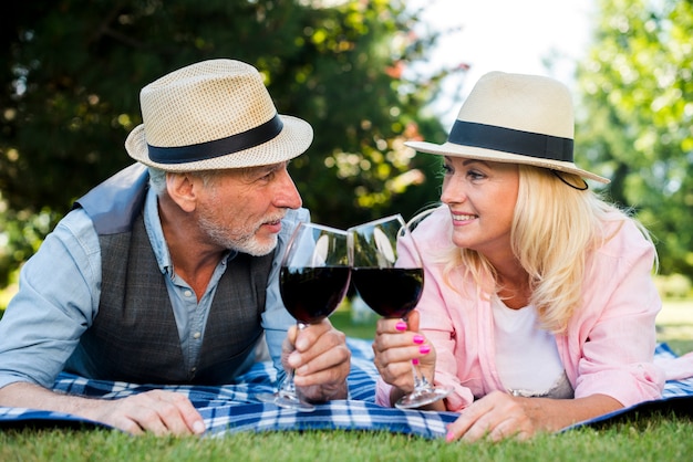 Couple laying on a blanket with wine and hats