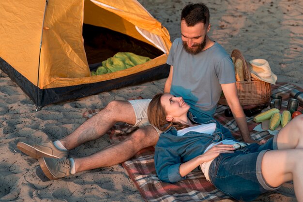 Couple laying down near tent