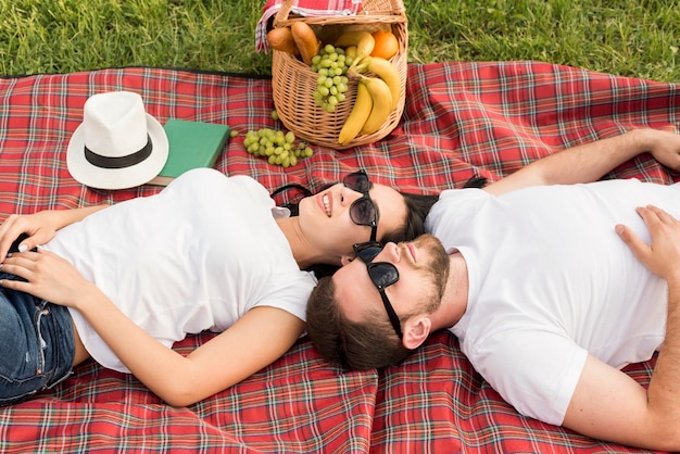 Foto gratuita coppia posa su una coperta da picnic