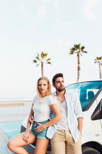 Couple leaning on car