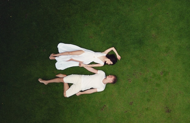 Couple lie on a graas on a Bali