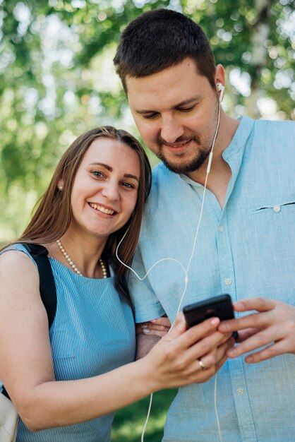 Couple listening to music on smartphone in park