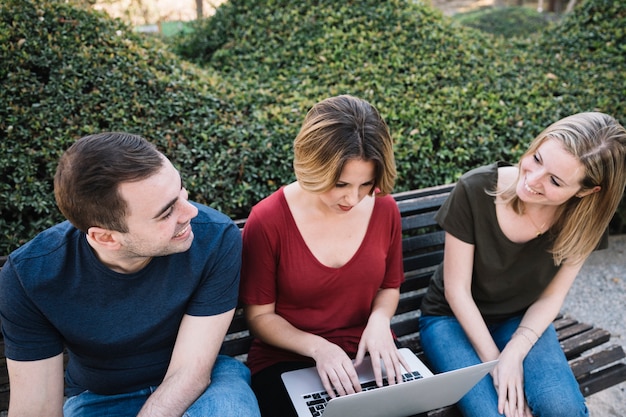 Couple looking at each other near woman with laptop