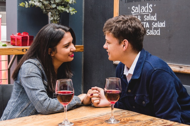 Couple looking at each other's eyes holding hands