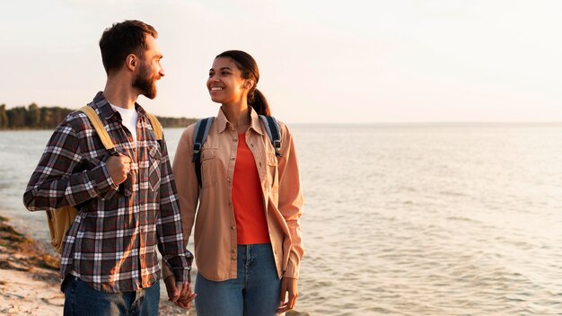 Пара смотрит друг на друга во время прогулки на берегу моря