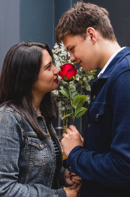 Couple looking at each other with a rose in the middle