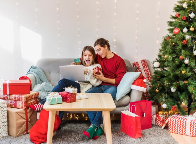 Couple looking at laptop screen on couch