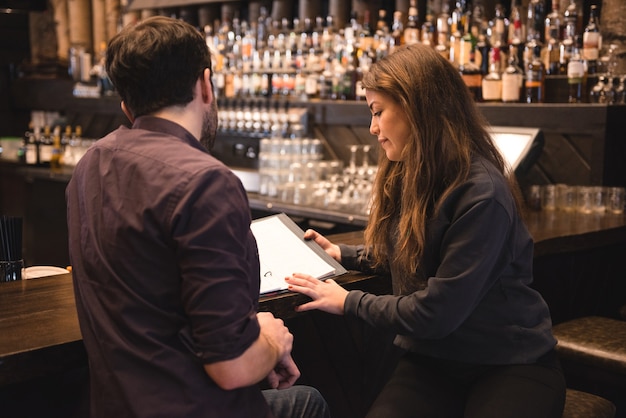 Foto gratuita coppia in cerca di menu al bancone del bar