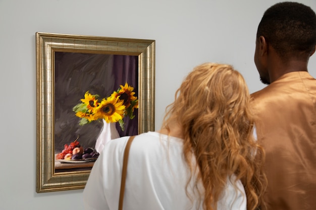絵画の後ろ姿を見ているカップル