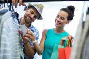 Free photo couple looking at price tag of clothes