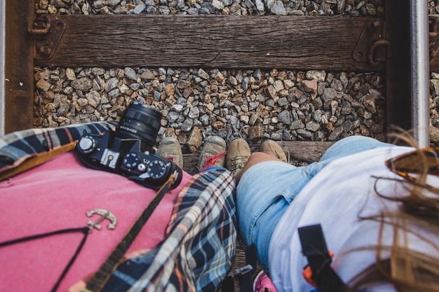 Free photo couple looking at their feet on train tracks