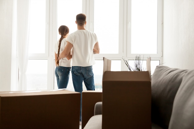 Couple looking through window planning future in new home