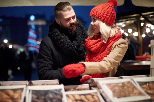 Coppia in amore comprando dolci al mercato locale