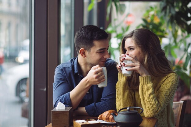 コーヒーショップでコーヒーを飲むことを愛するカップル