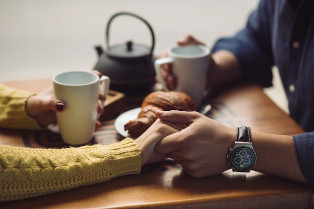 Couple in love drinking coffee. Hands close up