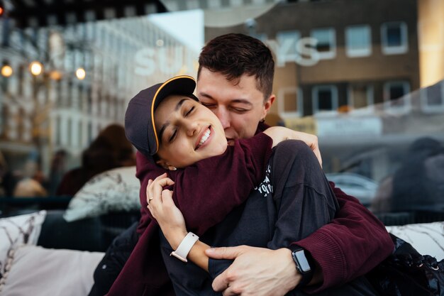 A couple in love. Guy and a girl are hugging at a table in a outdoor cafe.