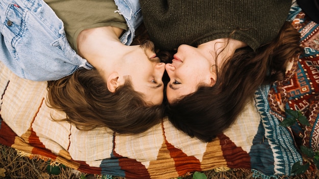 Free photo couple in love lying down in nature