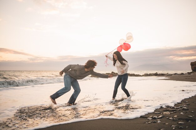 Couple in love playing and she with balloons in hand