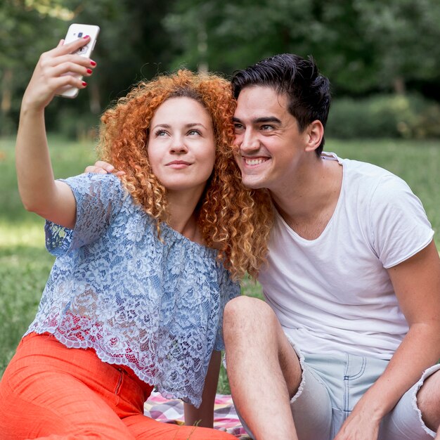 携帯電話で、selfieを取って愛のカップル