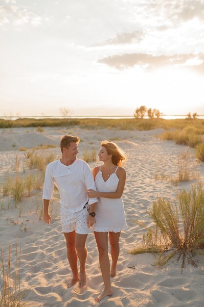 Влюбленная пара в белой одежде, прогулки по пляжу. Полная длина.
