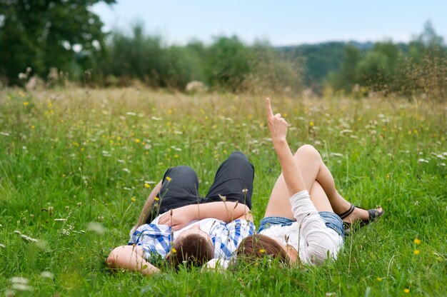 牧草地に横たわっているカップル