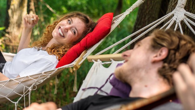 Couple lying on hammocks Young man is playing guitar