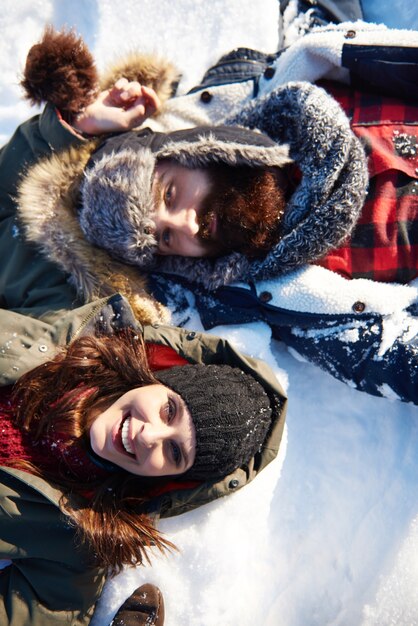 Couple lying on the white snow