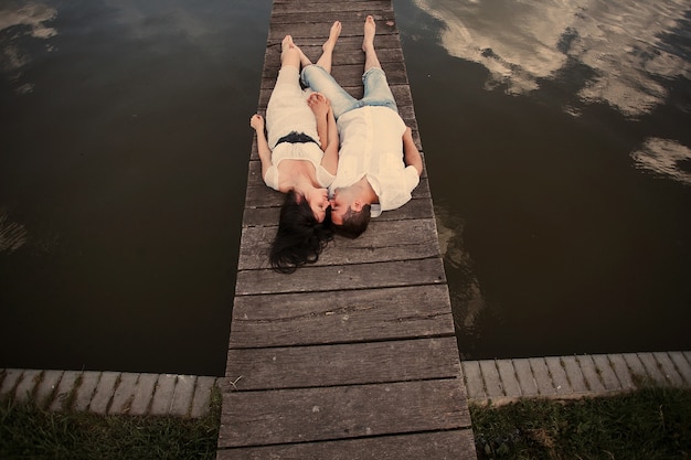 Couple lying in a wooden harbor 