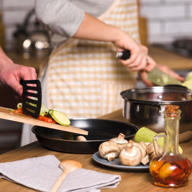 Couple making dishes for dinner at home 