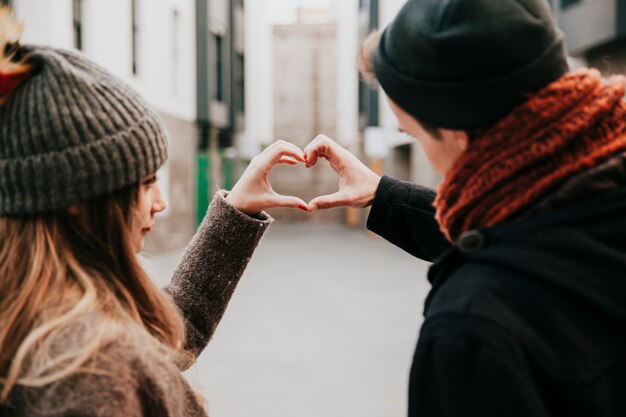 Couple making hand heart gesture