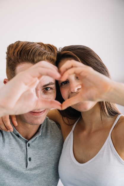 Couple making heart shape from hands 