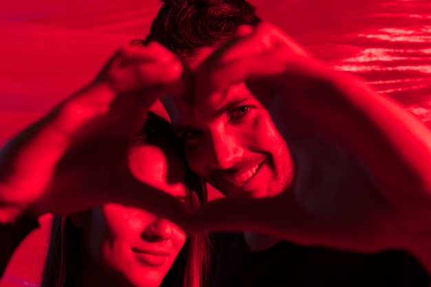 Couple making heart shape from hands
