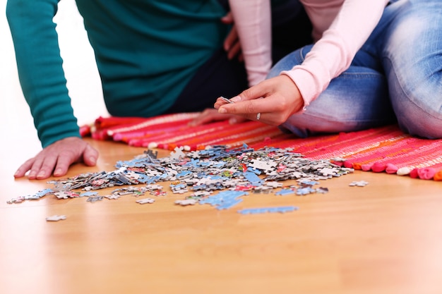 couple making puzzle on the floor