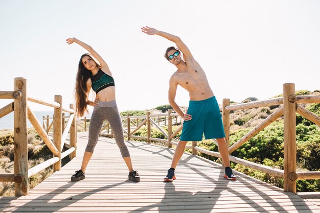 Couple making stretching exercise at the beach