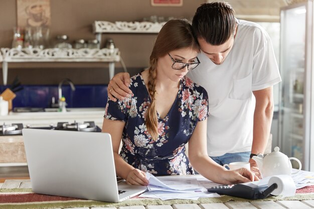 Couple managing budget together in kitchen
