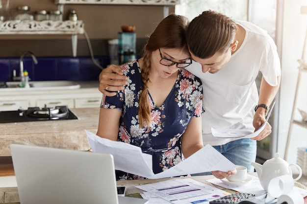 Free photo couple managing budget together in kitchen